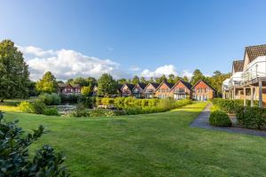 a row of houses in a park with a pond at Eurostrand Resort Lüneburger Heide in Fintel