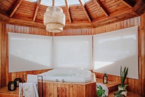 Cette chambre dispose d'une baignoire et d'un plafond en bois. dans l'établissement Hostería El Coirón, à Esquel