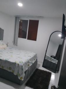 a bedroom with a bed and a mirror at Apartamento en el centro de la ciudad bonita a muy buen precio in Bucaramanga