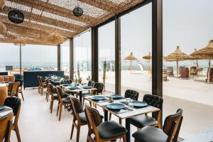 a dining room with tables and chairs and a beach at Tulum Beach Resort Dakhla in Dakhla