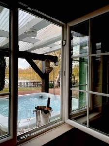 a window with a view of a swimming pool at L’Eden de JoLéo : votre cocon d’amour in Perthes