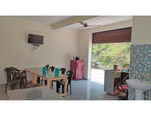 a living room with a table and chairs and a television at Amba Niwas Home Stay, Uttarkashi in Uttarkāshi