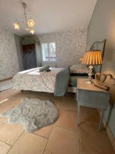a bedroom with a bed and a table with a lamp at L’Eden de JoLéo : votre cocon d’amour in Perthes