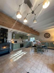 a large kitchen with a table and a fireplace at L’Eden de JoLéo : votre cocon d’amour in Perthes