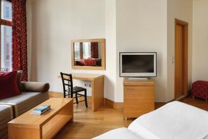 TV a/nebo společenská místnost v ubytování Le Palace Hotel