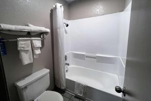 a bathroom with a tub and a toilet and a shower at Days Inn & Suites by Wyndham - Canton First Monday Trade Days in Canton