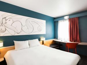 ルーベにあるibis Lille Roubaix Centre Grand-Placeのベッドとデスクが備わるホテルルームです。