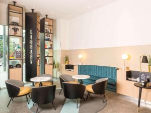 a restaurant with tables and chairs in a room at Aparthotel Adagio Brussels Grand Place in Brussels