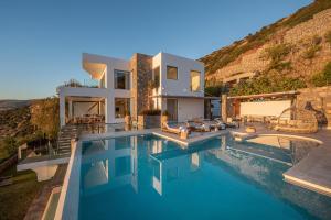 a villa with a swimming pool and a house at Lady Sea 6 Bedroom Villa with Heated Pool & Private Beach Access in Palaiokastro
