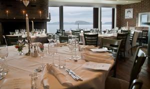 uma sala de jantar com mesas e cadeiras com copos de vinho em Scandic Hammerfest em Hammerfest