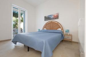 Un dormitorio con una cama con una manta azul. en Residence Mare Azzurro by BarbarHouse, en Porto Cesareo