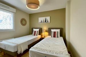 Łóżko lub łóżka w pokoju w obiekcie Appartement MerliDunes Proche de la plage