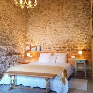 1 dormitorio con cama y pared de piedra en L'espigol "antiga era", en Sant Jordi Desvalls
