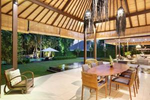 a dining room with a wooden table and chairs at Villa Bengawan in Canggu