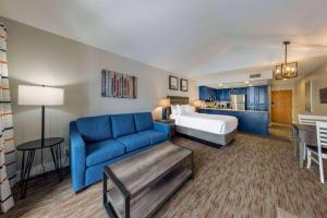 una camera d'albergo con un letto e un divano blu di Park Plaza Resort Park City, a Ramada by Wyndham a Park City