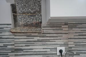 a room with a tile floor and a stone wall at Oásis Fonte Grande in Santo António +37 photos
