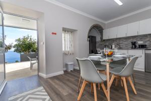 a kitchen and dining room with a table and chairs at Oásis Fonte Grande in Santo António