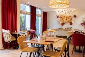 un ristorante con tavoli, sedie e lampadario a braccio di Aiden by Best Western Paris Roissy CDG a Roissy en France