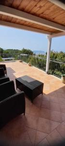 eine Terrasse mit einem Sofa und einem Tisch auf einer Terrasse in der Unterkunft Monolocale Mimosa in Pisciotta