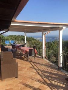eine Terrasse mit einem Tisch und Stühlen auf einer Terrasse in der Unterkunft Monolocale Mimosa in Pisciotta