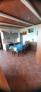 uma grande cozinha com uma mesa azul e cadeiras em Monolocale Mimosa em Pisciotta