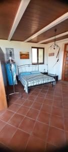 um quarto com uma cama e piso em azulejo em Monolocale Mimosa em Pisciotta