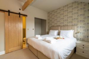 a bedroom with a large white bed and a wooden door at Alde Bay Farm - Oyster Catcher in Aldeburgh