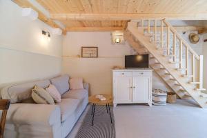 - un salon avec un canapé et un escalier dans l'établissement Stone bridge cottage, à Dol