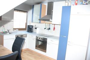 a kitchen with white appliances and a dining room table at Ferienwohnung 1 Jöbstl in Oberburgstall