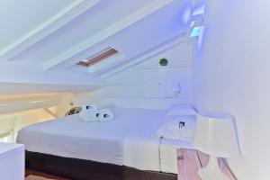 a bedroom with a bed with white sheets and a lamp at BmyGuest - Fado Mezzanine Apartment in Lisbon