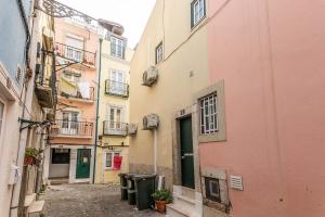 an alley between two buildings with trash cans at BmyGuest - Fado Mezzanine Apartment in Lisbon