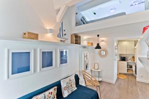 a living room with a blue couch and windows at BmyGuest - Fado Mezzanine Apartment in Lisbon
