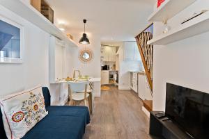 a living room with a blue couch and a kitchen at BmyGuest - Fado Mezzanine Apartment in Lisbon +20 photos