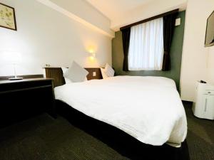 a hotel room with a white bed and a window at Eins.Inn Umeda Higashi in Osaka