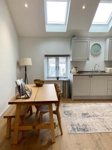 a kitchen with a wooden table and a kitchen with windows at 19a Brooks Road in Street