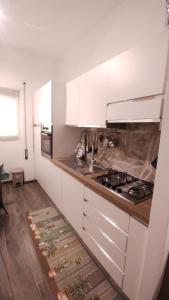 een keuken met witte kasten en een fornuis bij Appartamento Fiore Roma San Pietro in Rome