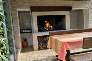 a fireplace with a table in front of it at Guesthouse Zagora in Pula