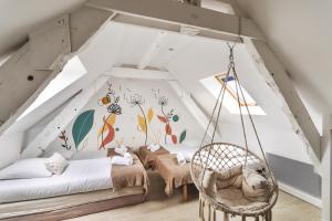 a room with a swing in a attic at Les Petits Matelots - Maison proche plage in Saint-Coulomb
