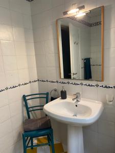 a bathroom with a sink and a mirror and a chair at Home Sweet Home in St Julian's