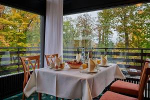 ein Esszimmer mit einem Tisch und einem großen Fenster in der Unterkunft Dorint Hotel & Sportresort Arnsberg/Sauerland in Neheim-Hüsten