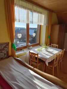 ein Esszimmer mit einem Tisch, Stühlen und einem Fenster in der Unterkunft Ubytovanie Gerlachov in Gerlachov