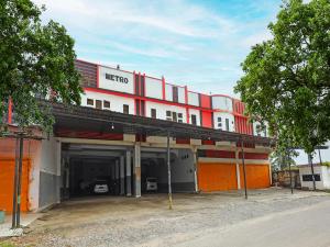 a large red and white building with a garage at OYO 92230 Penginapan Metro Parepare in Parepare