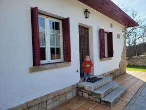 Un petit garçon debout à l'extérieur d'une maison dans l'établissement El Robledal - Miraflores de la Sierra, à Miraflores de la Sierra