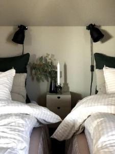 Vikingstad的住宿－Mysigt hus med utsikt över Östgötaslätten，一间卧室设有两张床,床头柜上放着蜡烛