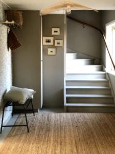 a room with stairs and a chair and a window at Mysigt hus med utsikt över Östgötaslätten in Vikingstad