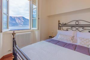 1 dormitorio con 1 cama y ventana grande en Aglaia Luxury Lake View by Wonderful Italy, en Abbadia Lariana