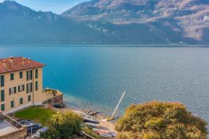 un edificio junto a una gran masa de agua con montañas en Aglaia Luxury Lake View by Wonderful Italy, en Abbadia Lariana