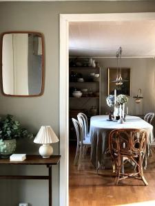 - une salle à manger avec une table, des chaises et un miroir dans l'établissement Mysigt hus med utsikt över Östgötaslätten, à Vikingstad
