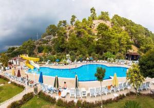 une grande piscine avec des chaises et des parasols dans un complexe dans l'établissement MIRAMOR HOTEL & Spa - ULTRA ALL INCLUSIVE, à Antalya