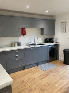 a kitchen with blue cabinets and a sink and a dishwasher at The Old Dairy in Great Ayton